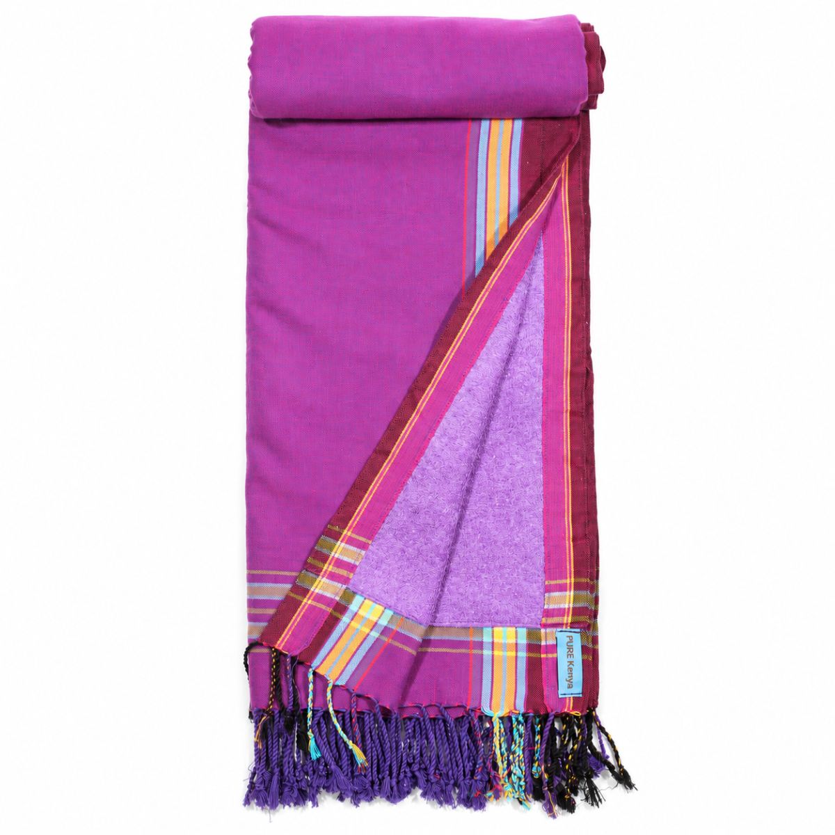 Opgevouwen PURE Kenya kikoy strandlaken Mandera Purple met paarse badstofvoering, gekleurde strepen en franjes.
